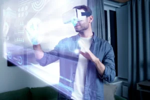 A man wearing a virtual reality headset is interacting with futuristic digital interfaces projected in front of him in a living room setting.