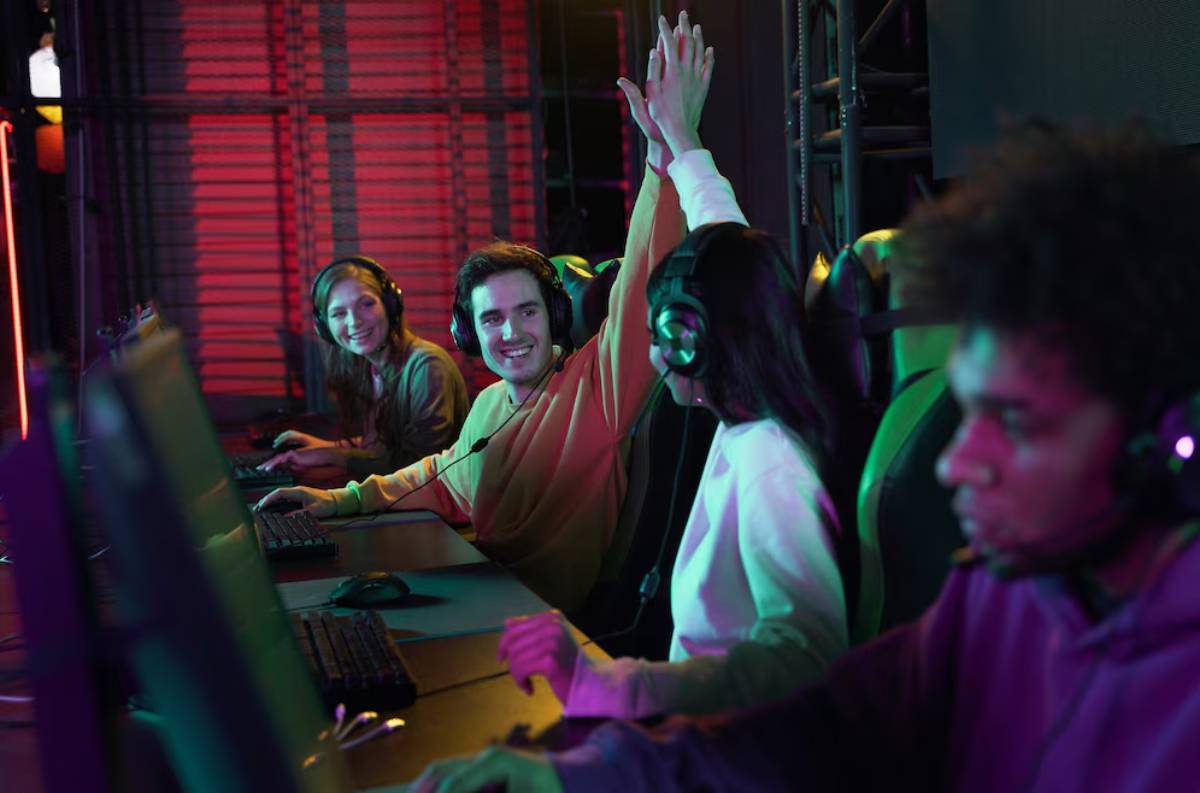 A group of gamers in a dimly lit room, intensely focused on their screens, with colorful lights illuminating the atmosphere.